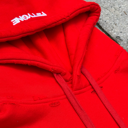 Red hoodie with upside down 'FIFTYONE' branding on the hood against a concrete floor background